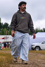 Man walking in Sky Blue Love Pants and the Dare to Love stone grey hoodie